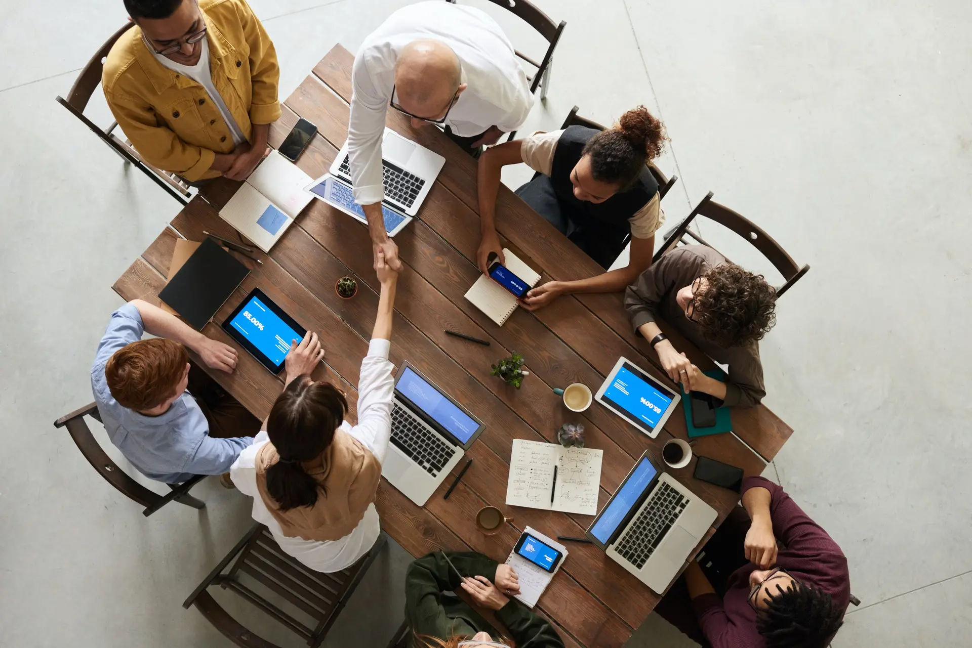 Team collaborating around a table with laptops during a client meeting